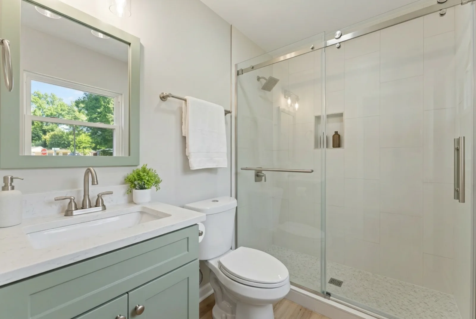 Remodeled Bathroom with Sage Green Vanity and Glass Shower